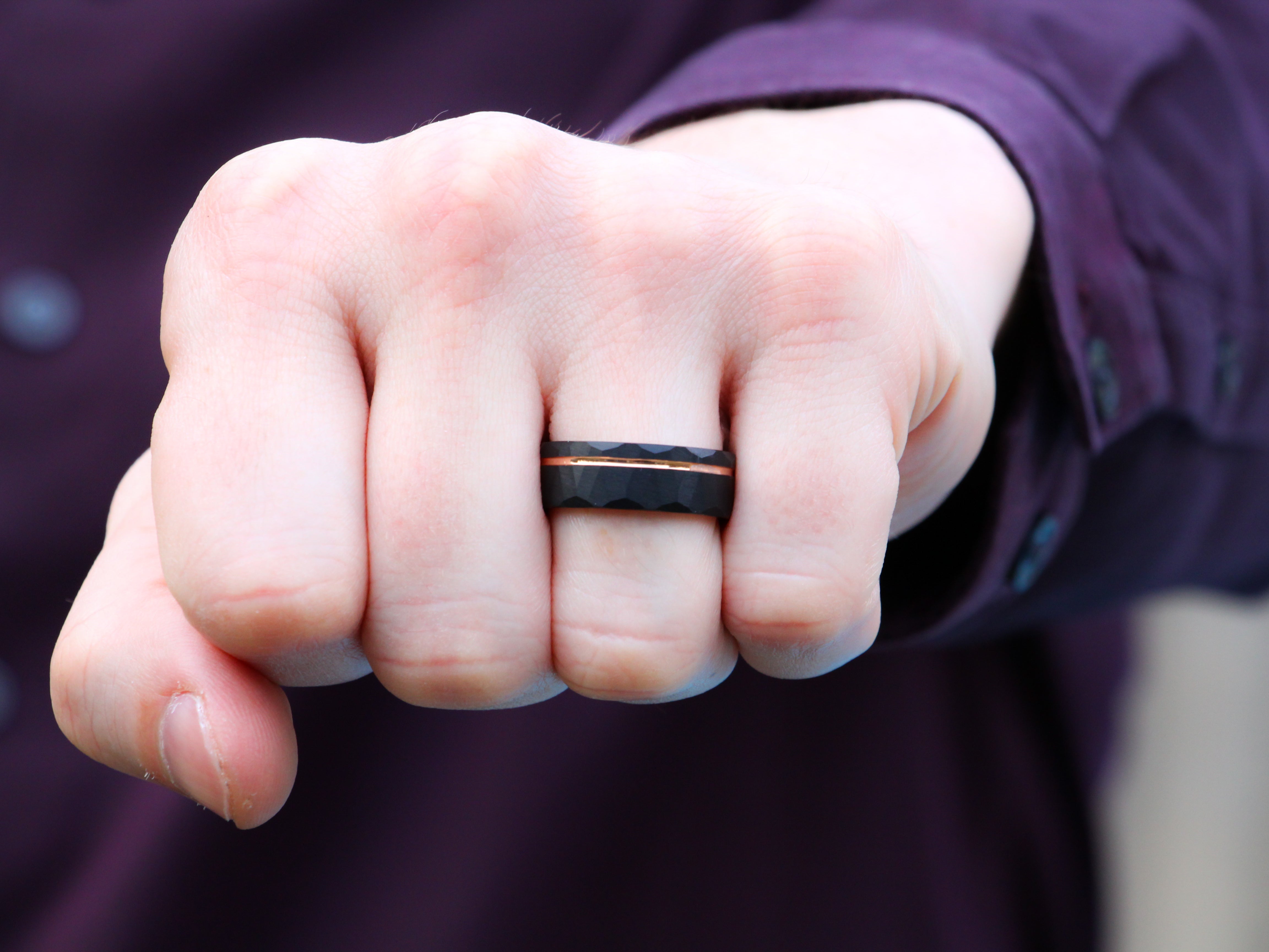 Black Hammered Tungsten Band with a Rose Gold Strip worn as a Men's Wedding Ring